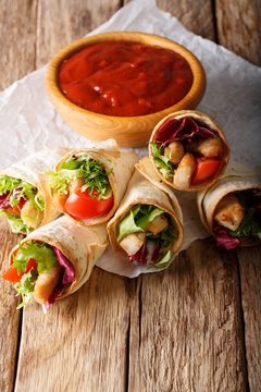 Delicious burrito with turkey, lettuce and vegetables close-up. vertical