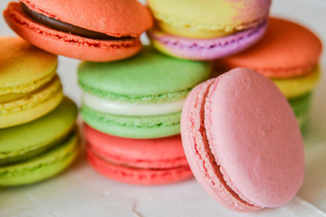 colorful macaroons in a gift box with a bright paper on a light background