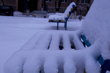 benches in the yard covered with snow