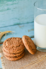 fresh oatmeal cookies with milk on wooden background