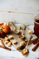 mulled wine in a mug and ingredients for making a drink on a white wooden background, top view