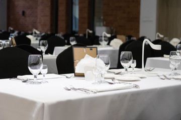 Black and white decor of the banquet hall, covered tables just before the party