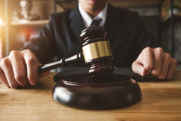 justice and law concept.Male judge in a courtroom with the gavel,working with,digital tablet...