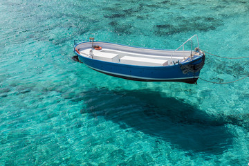 The rescue boat sails on the clear blue waters of the sea, casting a shadow on the bottom.