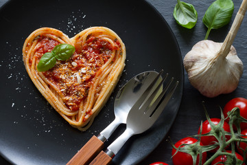 Spaghetti pasta heart love italian food diet abstract concept on black background
