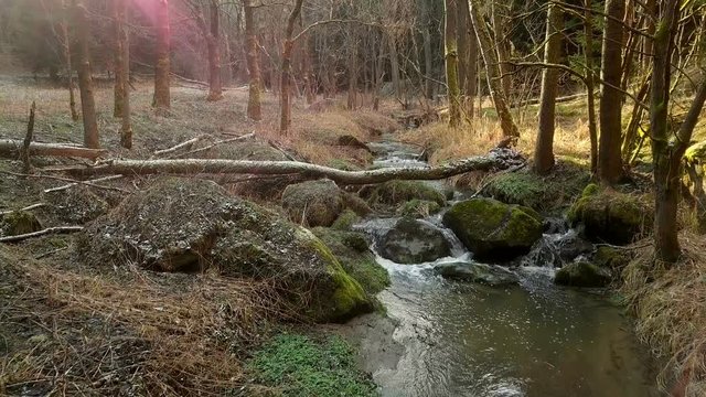 Water cascade on the small mountain river, aerial view with light leak and sun flare