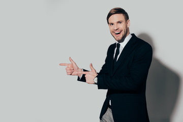 Stylish businessman in suit pointing on white background