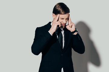 Businessman in suit suffering from headache on white background