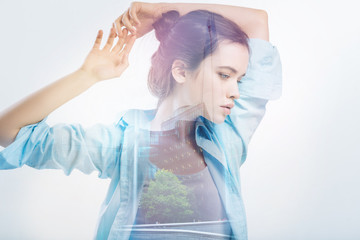 New view. Young curious beautiful woman standing on the bridge with her arms above her head and...