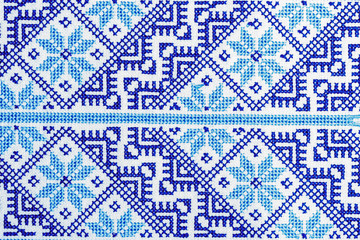 Traditional Ukrainian ornament embroidered with a cross on a linen cloth close-up