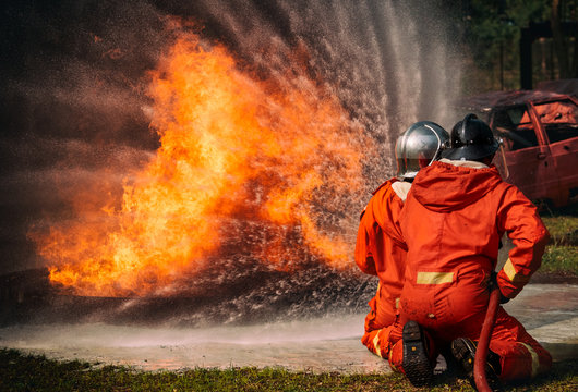 Firefighters water spray by high pressure nozzle in fire, Fire and rescue
