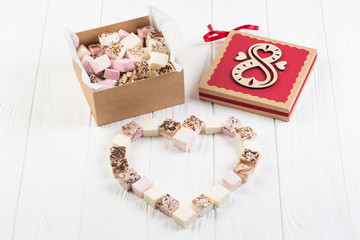 Assorted marshmallow on white wood table with gift box for eight march
