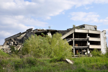 ruined house after bombing against the blue sky