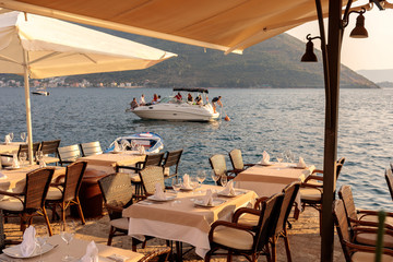 Leisure in Montenegro. Yacht and beach restaurant by the sunset light in Kotor