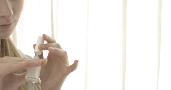 Beautiful woman pinting her nails with lacquer