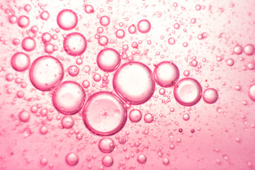 Pink oil bubbles on water surface