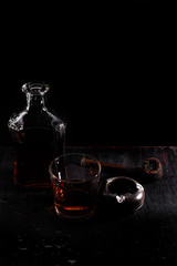 Glass of whiskey with smoking cigar.