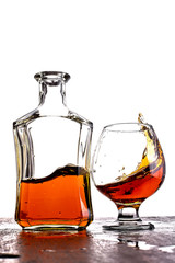 Glass of splash whiskey with bottle.