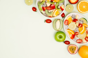 Bowl of healthy fresh fruit salad on wooden background. Top view.