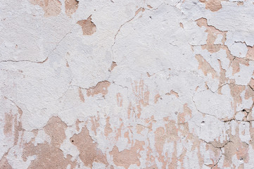 Textured background white cracked plaster partially sprinkled with a pink shaded cracked wall. Grunge background