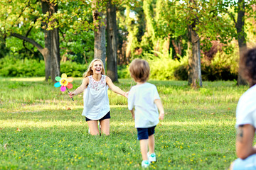 Fototapeta premium Szczęśliwa rodzina gra w parku. Matka, ojciec i syn bawią się razem na łonie natury latem, wiosną.