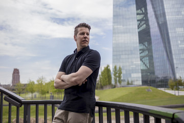 Man Leaning on Outdoor Balustrade, and Skyscraper