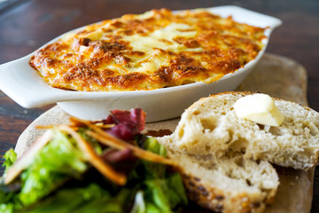Raclette Tartiflette - french kitchen. Meat casserole on a wooden board. Close-up