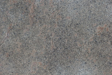 Grauer Betonboden mit farbigen Kieselsteinen