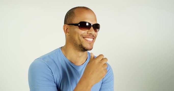 4K Laid back mixed race man wearing sunglasses & posing on white background in studio shoot