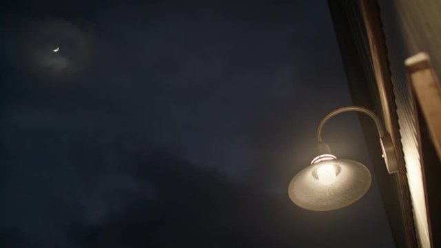Shot of a street lamp and the moon at night.