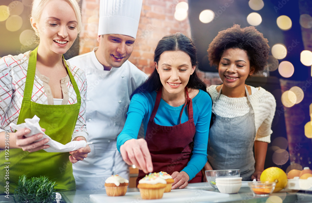 Wall mural happy women and chef cook baking in kitchen