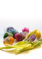 Fototapeta na wymiar Easter Time, colorful painted eggs and spring tulips on bright background
