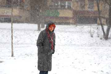 Fototapeta na wymiar Senior woman walking on blizzard day in park