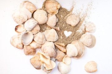 Heart drawn on the sand on the beach among seashells. Vacation, beach.