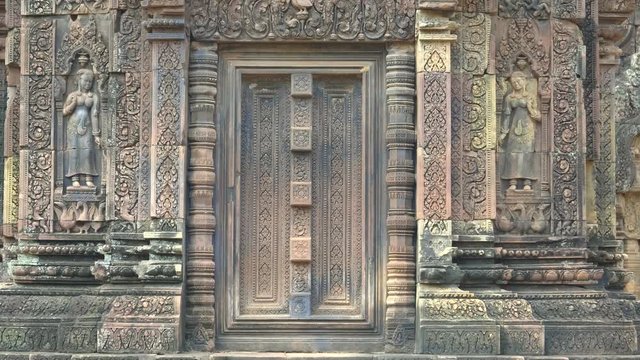 two devata carved in a wall of banteay srei temple at angkor, cambodia