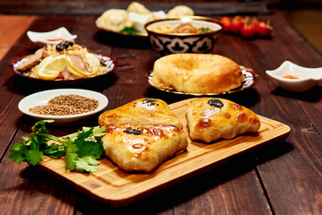 Caucasian food dark background. Samsa, plov, noodle, meat, lavash, manti, tomato, sauce. Caucasian restaurant concept. Space for text.