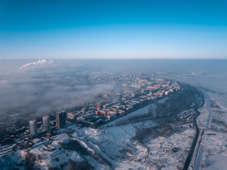 city ​​view from a bird's eye view to a winter city at dawn in the fog