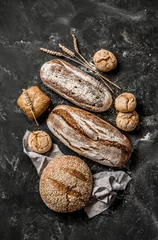 Gardinen Bäckerei - rustikale knusprige Brotlaibe und Brötchen auf Schwarz © pinkyone