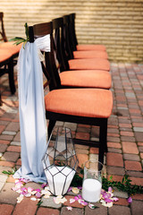 Decorated coral chairs on open air wedding ceremony