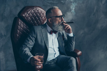 Side profile view of  thoughtful, serious, minded, ponder rich man in glasses, smoke cigarette,...