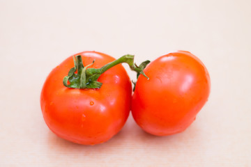 Two red tomatoes with water drops. Fresh vegetables for a healthy diet