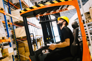 Warehouse worker doing logistics work with forklift loader