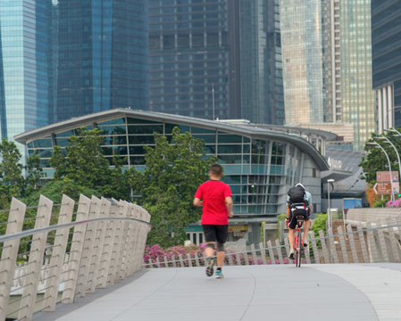 Runners and cyclists exercise in the morning along the bridge near Marina Bay in Singapore