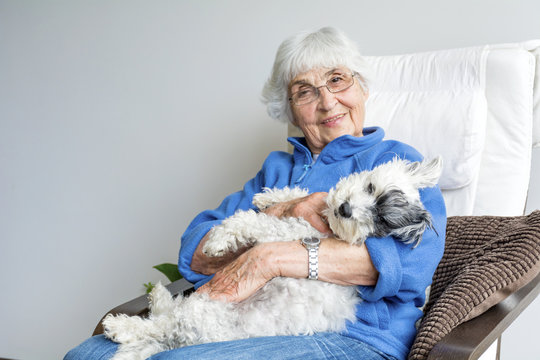 Happy Senior Woman Hugging Her Dog At Home