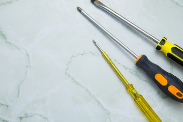 Home, House Repair, Redecorating, Renovating Concept. A set of repair tools on a white grid: three screwdrivers, top view, flat lay
