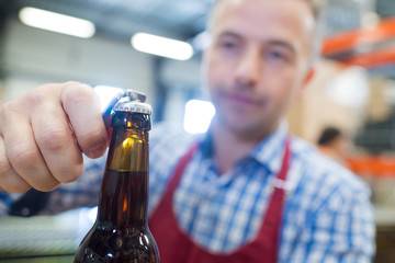 closeup of male opening beer bottle
