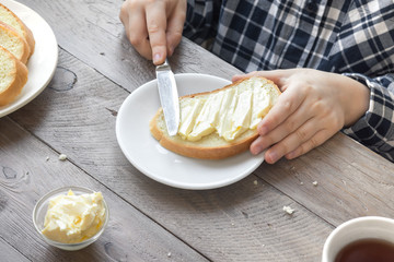 hands spreading butter on bread