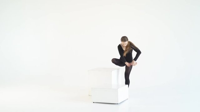 young blonde woman dancing on isolated white background. Staging emotional choreography. a lot of expression in the movements. dance on a white cube in a cycramrame 4k