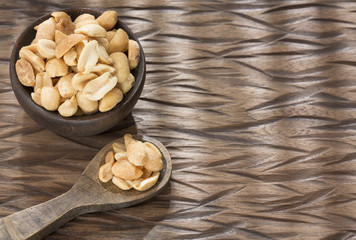 Toasted peanuts on wooden background - Arachis hypogaea