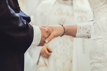 Moment przysięgi małżeńskiej na ślubie kościelnym. Zbliżenie na dłonie - obrazy, fototapety, plakaty